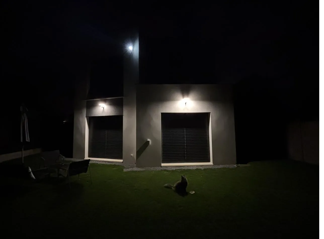 Façade d'une maison de nuit en Essonne, éclairage extérieur allumé et brise-soleil baissés
