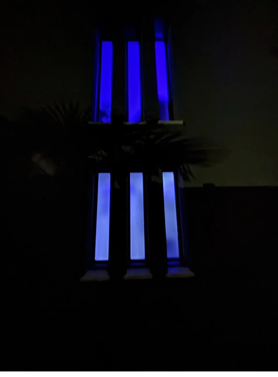Fenêtres verticales d'une façade éclairées en bleu de nuit par un éclairage RGB
